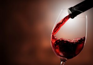 Vinho tinto, derramando em uma taça de vidro