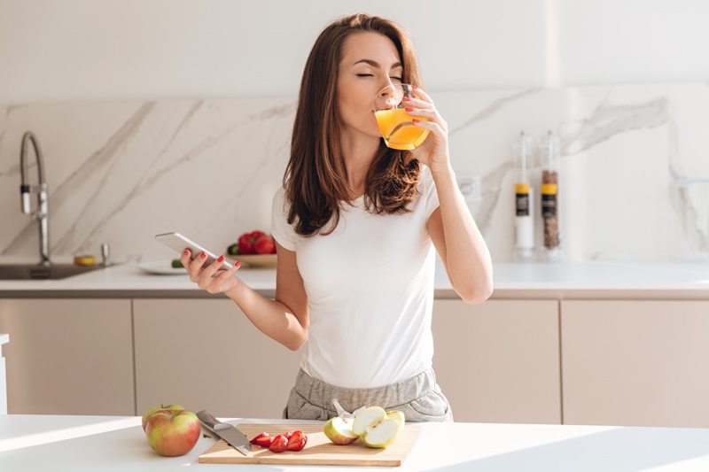mulher tomando suco de laranja vitamina - Magnus Personal