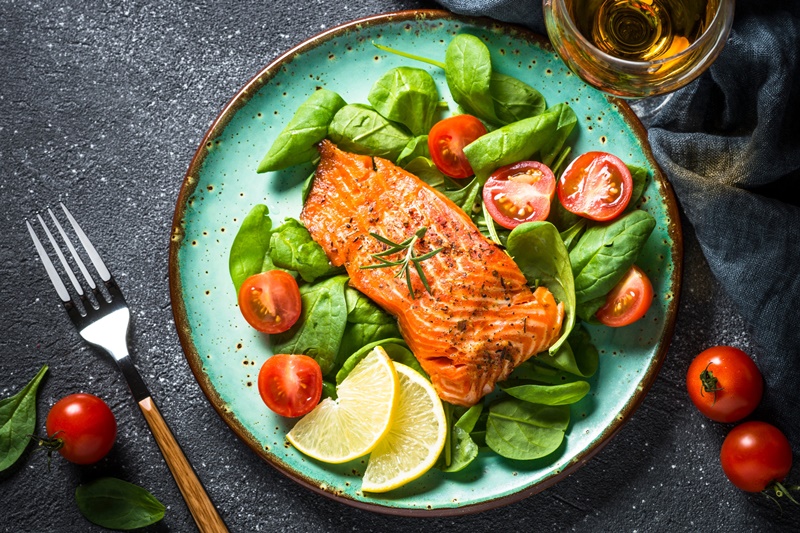 Filé de peixe salmão assado com vista superior de salada fresca. | Magnus Personal Trainer
