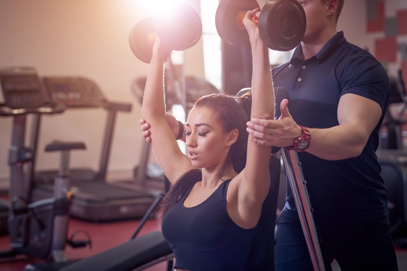 treino de mulher com personal trainer com equipamento de musculação - Magnus