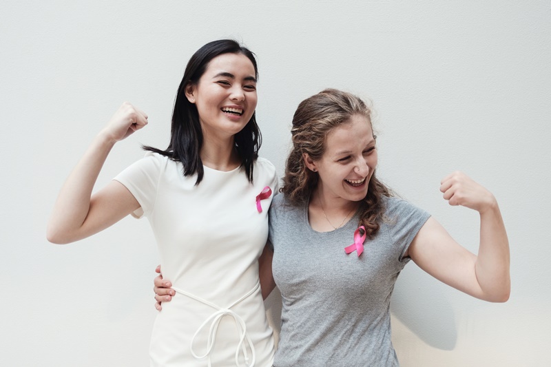 mulheres jovens multiculturais com fitas cor-de-rosa, conscientes do câncer de mama | Magnus Personal Trainer