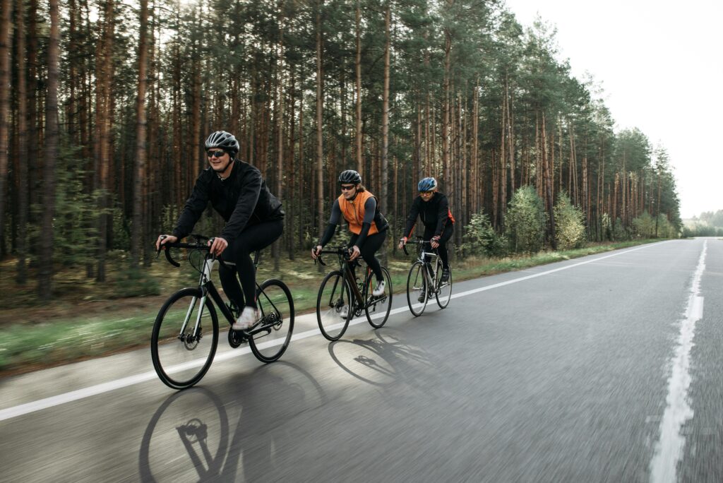 três pessoas fazendo ciclismo, uma exercício que ajuda a reduzir o estresse
